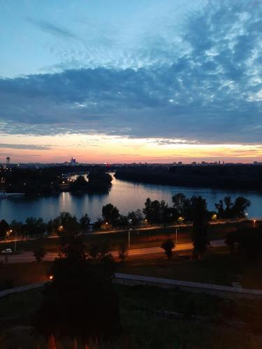 a view of a river at sunset at Apartments best city place in Belgrade