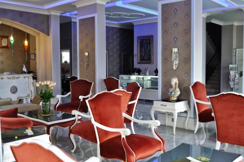 a waiting room with red chairs and a table at Grand Atakum Hotel in Samsun