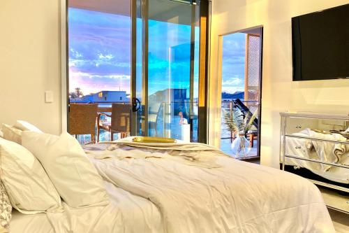 a bedroom with a large white bed with a large window at AdriaticBlu Luxe 2 bed apartment with stunning ocean views in Perth