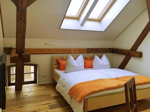 a bedroom with a bed with orange and white pillows at Doppelzimmer Brauhaus 3 in Königsberg in Bayern