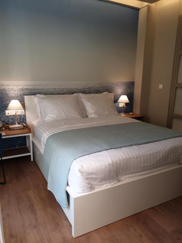 1 cama grande en un dormitorio con 2 lámparas en las mesas en Newly Renovated Studio 15 min walk from Acropolis, en Atenas