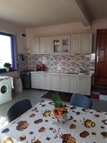 a kitchen with a table and chairs and a counter top at Becze Vanda kulcsosház in Lăzarea