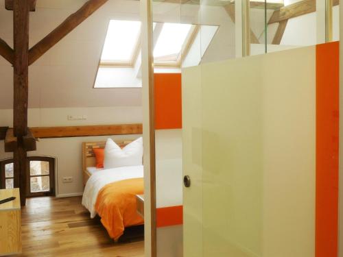 1 dormitorio con paredes de color naranja y blanco y 1 cama en Doppelzimmer Brauhaus 3 en Königsberg in Bayern