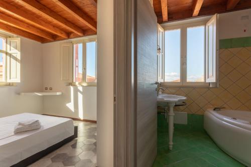 a bathroom with a bed and a tub and a sink at Maison Belle Époque & suites in Oristano