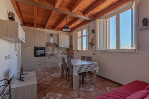 a kitchen and dining room with a table and chairs at Maison Belle Époque & suites in Oristano