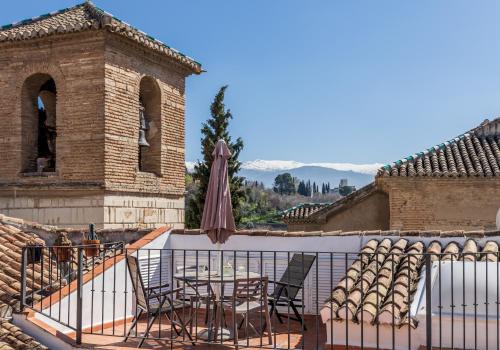 a patio with chairs and a table and an umbrella at San José Apartments in Granada