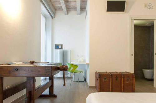 ヴェローナにあるResidenza Cardo Massimoの木製デスクと緑の椅子が備わる客室です。