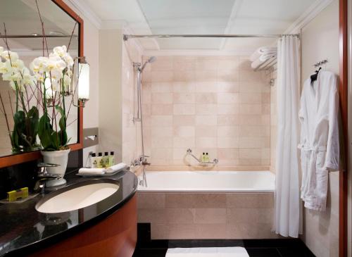 a bathroom with a tub, sink, and mirror at InterContinental Budapest, an IHG Hotel in Budapest