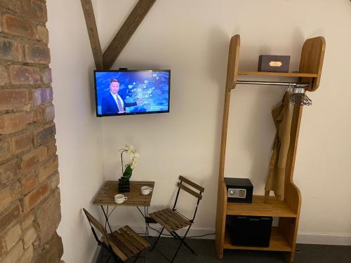 a room with a tv on a wall with a table at Royal Mile Balconies by the Castle in Edinburgh