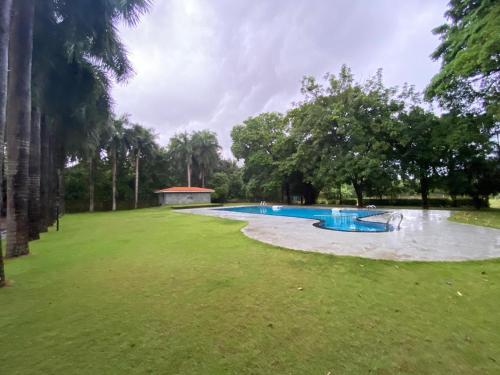 een groot zwembad in een park met bomen bij Hotel KPM Tripenta in Palakkad
