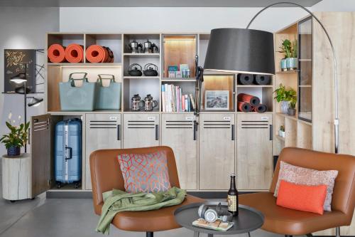 a living room with two chairs and a table at Stay KooooK Bern Wankdorf - Online Check In in Bern