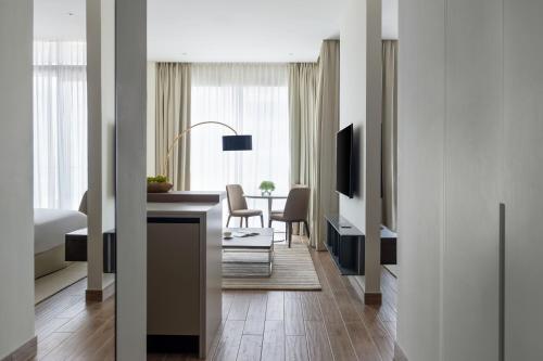 a living room with a desk and a dining room at Jumeirah Living Marina Gate Dubai in Dubai