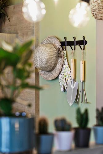 a hat and two candles on a wall with plants at Stay KooooK Bern Wankdorf - Online Check In in Bern