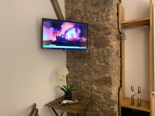 a flat screen tv hanging on a stone wall at Royal Mile Balconies by the Castle in Edinburgh