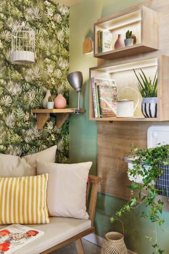 a living room with a couch and a green wall at Stay KooooK Bern Wankdorf - Online Check In in Bern