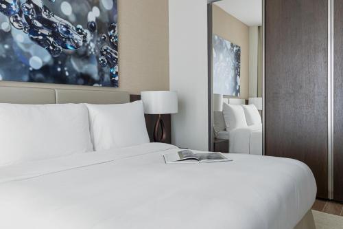 a bedroom with a white bed with a book on it at Jumeirah Living Marina Gate Dubai in Dubai