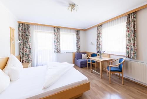 ein Hotelzimmer mit einem Bett, einem Tisch und Stühlen in der Unterkunft Apart Elisabeth in Hippach