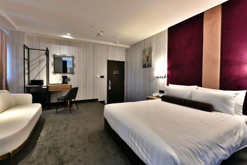 a hotel room with a large bed and a desk at Mayer Inn in Taipei