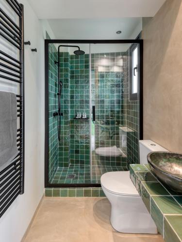 a bathroom with a shower and a toilet and a sink at Muse Urban Suites in Athens
