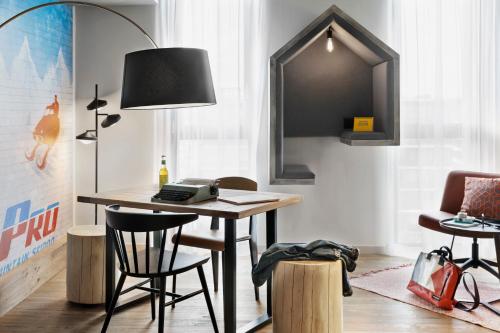 a room with a desk with a lamp and chairs at Stay KooooK Bern Wankdorf - Online Check In in Bern