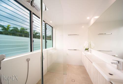 a bathroom with white walls and a large window at Splendeur Sur La Mer - One Bedroom in Airlie Beach