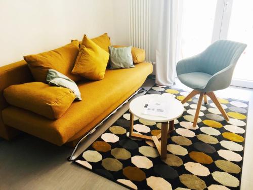 a living room with a yellow couch and a blue chair at Burghof Kyffhäuser in Bad Frankenhausen
