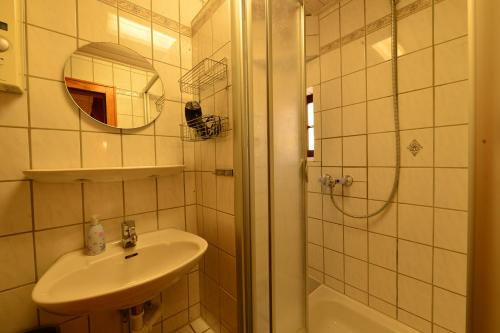 a white bathroom with a sink and a shower at Wiekhaus 49 in Neubrandenburg