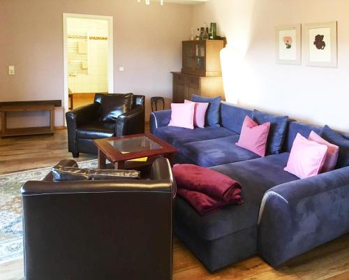a living room with two blue couches and pink pillows at Burghof Kyffhäuser in Bad Frankenhausen