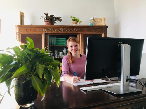 a woman sitting at a desk with a computer at Burghof Kyffhäuser in Bad Frankenhausen