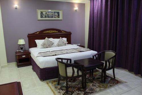 a bedroom with a bed and a table and chairs at Al Diyar Hotel in Nizwa