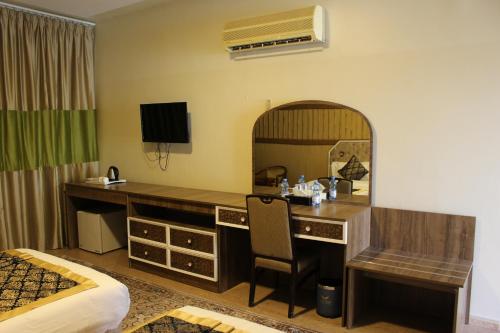 a hotel room with a desk and a mirror at Al Diyar Hotel in Nizwa