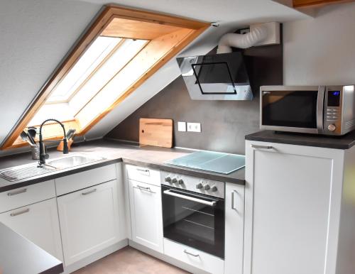 a kitchen with a stove and a microwave at Ferienwohnung Zum Steinberg in Bredstedt