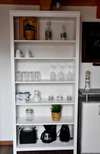 a shelf full of glass items in a kitchen at Ferienwohnung Zum Steinberg in Bredstedt