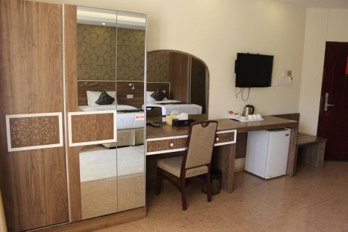 a hotel room with a desk and a bed at Al Diyar Hotel in Nizwa