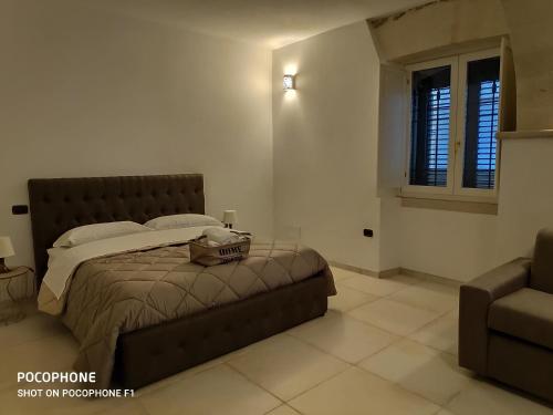 a bedroom with a bed and a couch and a window at Appartamento Suite Santa Teresa in Taranto