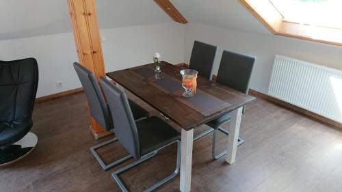 a wooden table with chairs and a vase on it at Ferienwohnung Zum Steinberg in Bredstedt