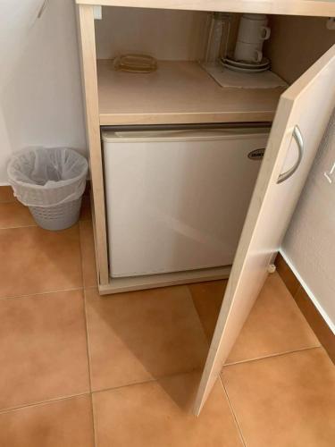 a cupboard in a kitchen with a trash can at Vouros Palace in Masouri