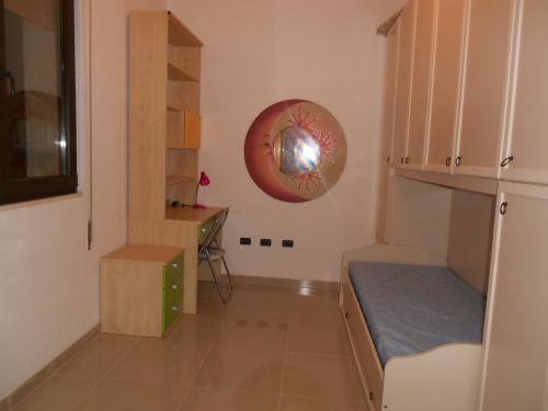 a small room with a bed and a shelf at Casa Batti in Oristano