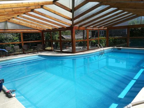 uma grande piscina com telhado de madeira em Casa Oute em Sobrada