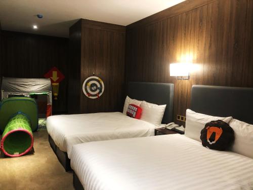 a hotel room with two beds with white sheets at Mayer Inn in Taipei