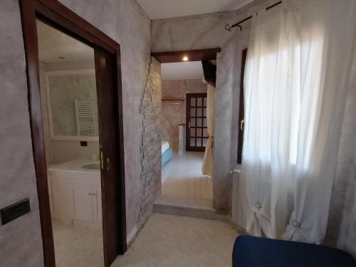 a bathroom with a door leading to a bathroom with a sink at Sardinia B&B house in Olbia