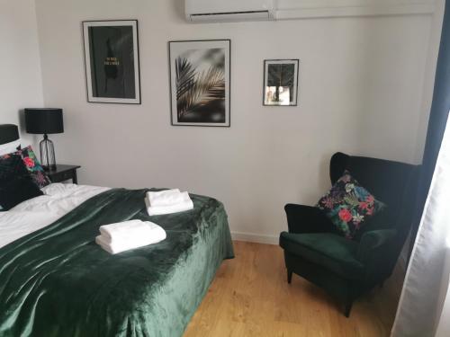 a bedroom with a bed and a chair at Apartamenty Dukla in Dukla