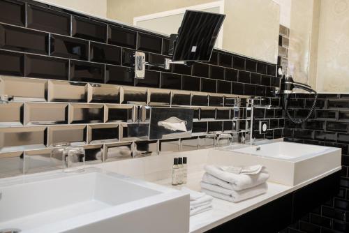 a black and white bathroom with two sinks and a mirror at Art Hotel in Rochecorbon