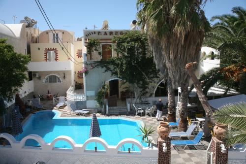 a swimming pool in front of a building at Villa Markos in Perissa
