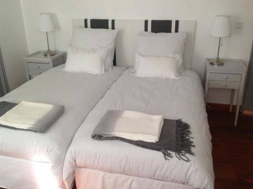 1 dormitorio con 2 camas, sábanas blancas y toallas en La Maison Carolane en Latour-de-Carol