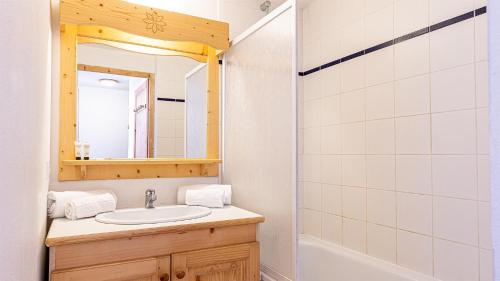 a bathroom with a sink and a mirror and a tub at Madame Vacances Residence Les Fermes de Saint Sorlin in Saint-Sorlin-dʼArves