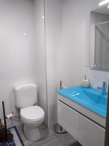 een badkamer met een toilet en een blauwe wastafel bij Apartamento Balsa 2 in Viseu