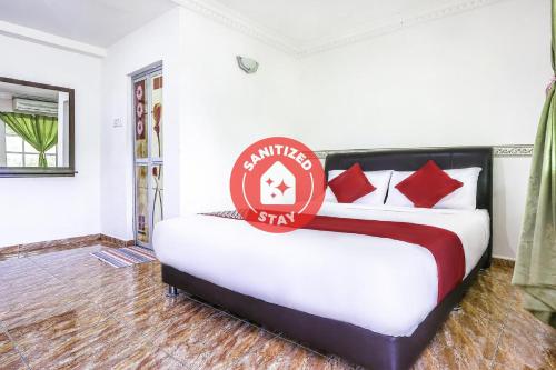 a bedroom with a bed with a sign on it at D' Anjung Inn in Tangkak