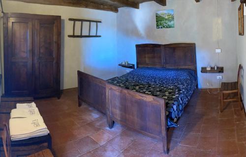 uma cama de madeira num quarto com em BBB Bed&Breakfast Bagneri em Muzzano