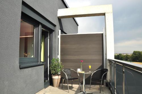 a patio with a table and chairs on a balcony at Motel am Fürfelder Schloss in Bad Rappenau